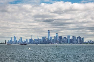 Aşağı Manhattan 'daki Battery Park' ı çevreleyen gökdelenlerle New York şehrinin geniş panoramik manzarası. Bir Dünya Ticaret Merkezi binalar arasında dimdik dururken, Özgürlük Heykeli çerçevenin sol tarafında görülebiliyor. AC 'den alındı.