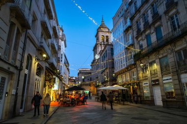Katedralimiz 'in çan kulesi büyüleyici bir sokak sahnesinin üzerinde yükselir, Noel ışıklarının yumuşak parıltısıyla yıkanır..