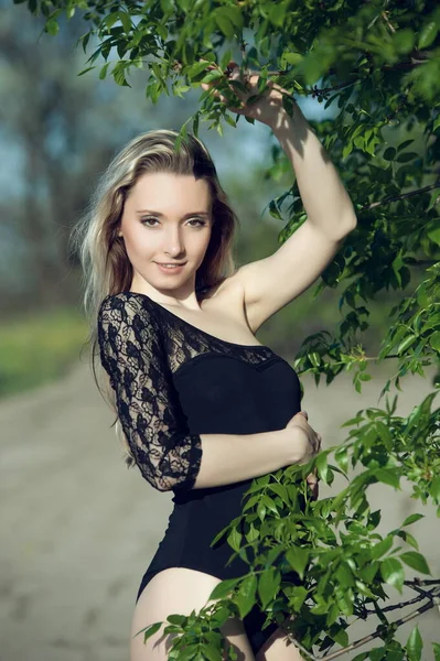 美しいですセクシーブロンド女の子で黒ブラウスポルノの緑の葉 — ストック写真
