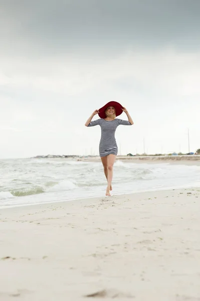 Сексуальная Блондинка Полосатом Платье Красной Шляпе Бегает Пляжу — стоковое фото