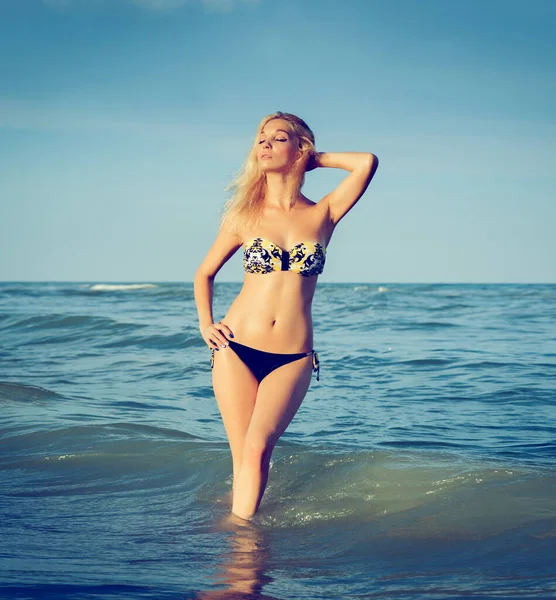 美しいですセクシーブロンド女の子で水着Posingオンザ砂の海のビーチ近くにザ水 — ストック写真