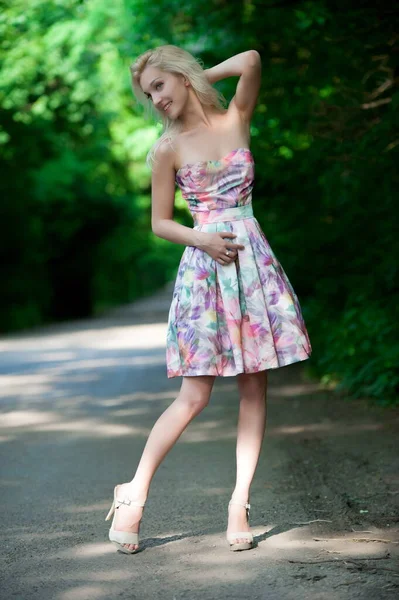 在一个阳光灿烂的夏日 美丽的金发姑娘在路边摆姿势 — 图库照片