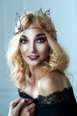 Kafasında tacı olan güzel, sarışın bir kızın portresi.