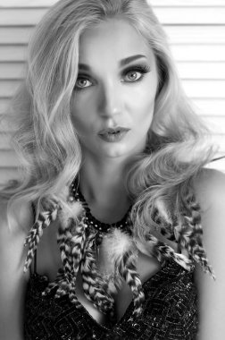 Ensesinde tüy süsü olan güzel, sarışın bir kızın portresi.