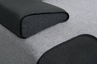 Yastıklı gri bir kanepe parçası, yakın plan, izole edilmiş beyaz bir arka plan.