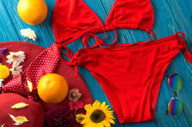 Çiçekler, şapka, turuncu, güneş gözlüğü ve kırmızı mayoyla dolu bir yaz. Arkaplan