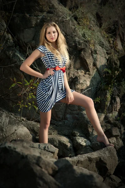Сексуальная девушка в полосатом платье на скалах — стоковое фото