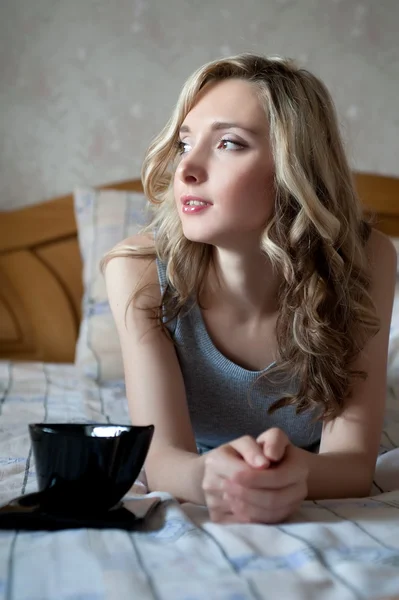 Blond meisje liggend op bed — Stockfoto