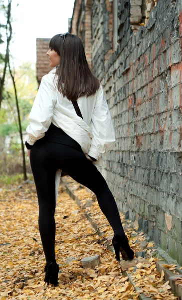 Mädchen posiert mit alter Mauer — Stockfoto