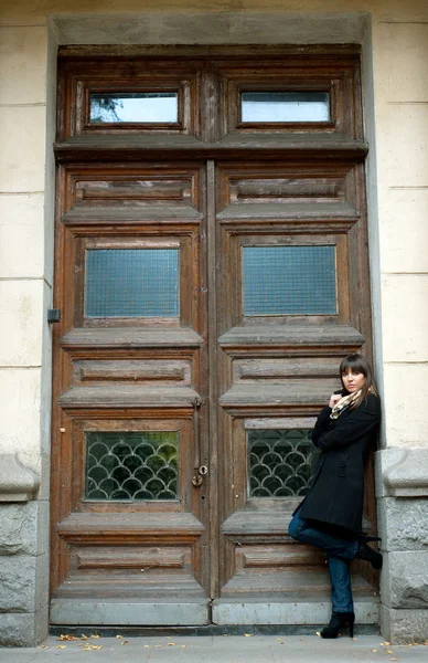 Menina posa com porta de madeira — Fotografia de Stock