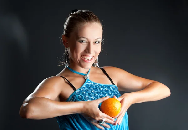 Girl in blue dress with orange fruit — Stock Photo, Image