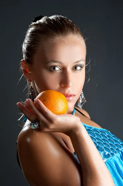 Girl in blue dress with orange fruit — Stock Photo, Image