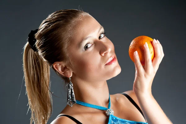 Girl in blue dress with orange fruit — Stock Photo, Image