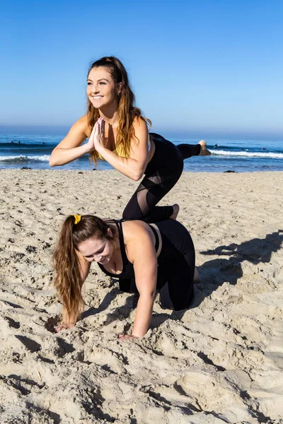 在海滩上做瑜伽的年轻女性 — 图库照片