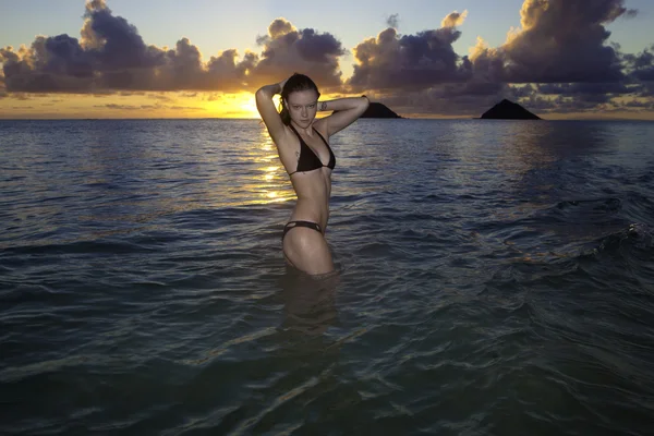 Flicka på stranden vid soluppgången — Stockfoto