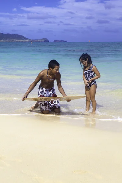 Junge bringt Schwester Skimboard bei — Stockfoto