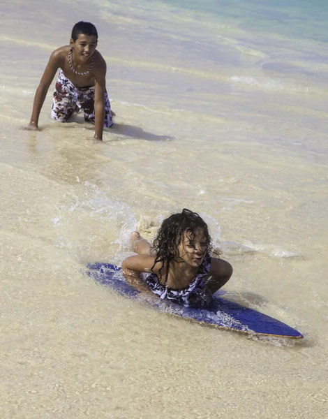 Boy teaching sister to skim board — Stock Photo, Image