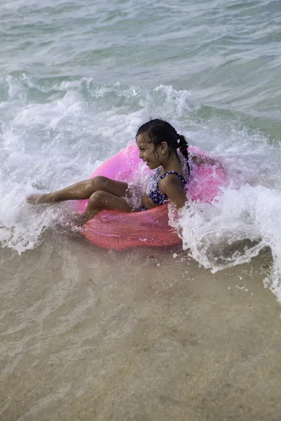 Niña flotando en una balsa rosa —  Fotos de Stock