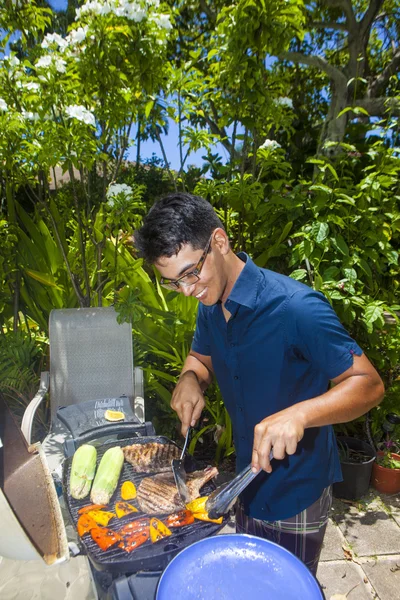 Uomo grigliate nel suo giardino — Foto Stock