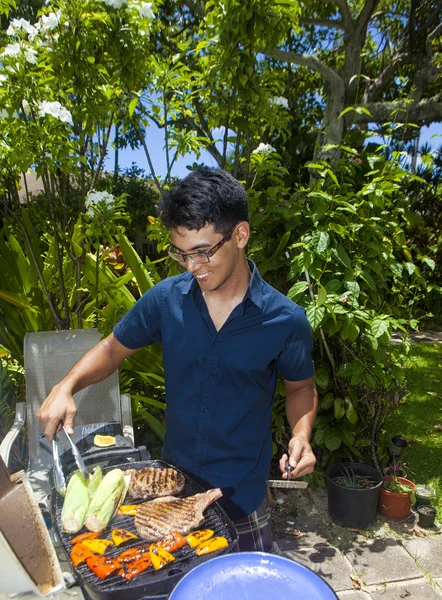 Man barbecueën in zijn tuin — Stockfoto