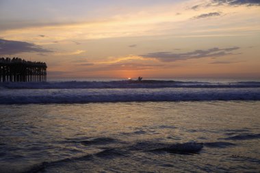 Gün batımında sörfçü