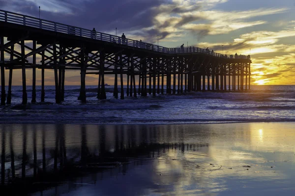 Zonsondergang op de Stille Oceaan strand pier — Stockfoto