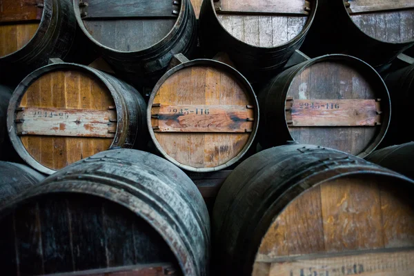 Barricas de vino apiladas en la bodega — Foto de Stock