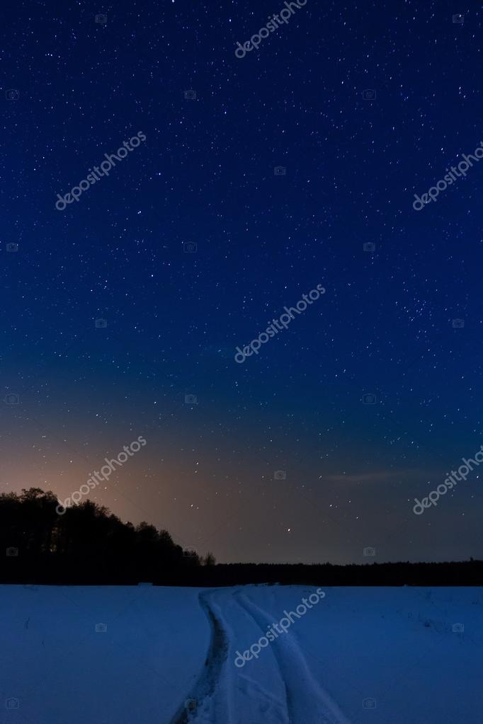 星降る夜空の背景に雪に覆われた道 ストック写真 C Alexust