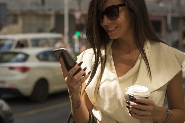 Moderní mladá brunetka se směje do telefonu — Stock fotografie