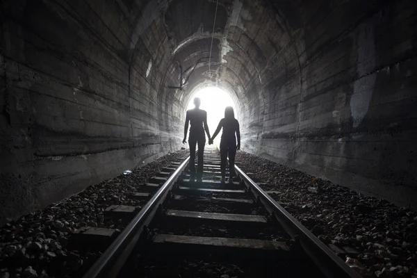 Couple walking together through a railway tunnel — Stock Photo, Image