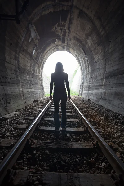 Man in a tunnel looking towards the light — Stock Photo, Image