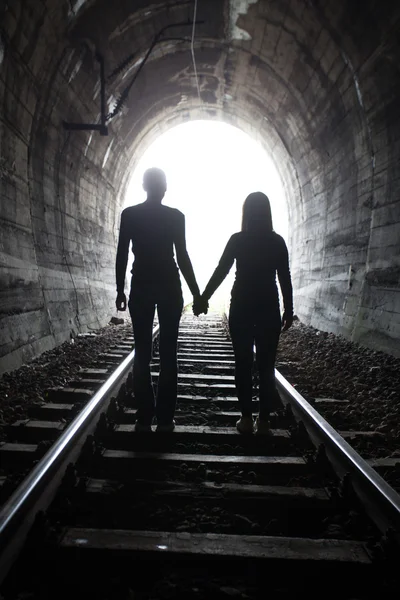 Couple marchant ensemble à travers un tunnel ferroviaire — Photo