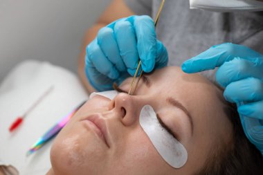 Kirpiklerin iyileştirme prosedürü Cımbızla uzatılmış uzun kirpikli kadın gözleri