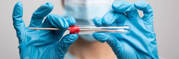 Medical healthcare nurse holding Coronavirus COVID-19 swab test kit, PPE protective mask and gloves, tube for taking OP NP patient specimen sample, PCR DNA RNA testing protocol process stock photo