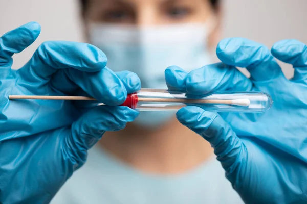 Medical healthcare nurse holding Coronavirus COVID-19 swab test kit, PPE protective mask and gloves, tube for taking OP NP patient specimen sample, PCR DNA RNA testing protocol process stock photo