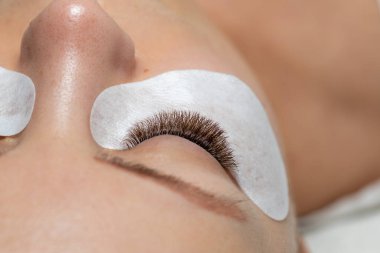 Güzellik tedaviden sonra göz bandıyla uzun kirpikli bir kadın gözü.