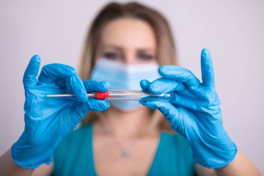 Coronavirus COVID 19 test kiti, PPE koruyucu maskesi ve eldiven taşıyan yüz maskeli hemşire, OP NP hasta numunesi almak için tüp, PCR DNA RNA test protokolü fotoğrafı