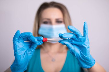 Coronavirus COVID 19 test kiti, PPE koruyucu maskesi ve eldiven taşıyan yüz maskeli hemşire, OP NP hasta numunesi almak için tüp, PCR DNA RNA test protokolü fotoğrafı