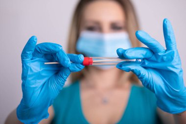 Coronavirus COVID 19 test kiti, PPE koruyucu maskesi ve eldiven taşıyan yüz maskeli hemşire, OP NP hasta numunesi almak için tüp, PCR DNA RNA test protokolü fotoğrafı