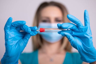 Coronavirus COVID 19 test kiti, PPE koruyucu maskesi ve eldiven taşıyan yüz maskeli hemşire, OP NP hasta numunesi almak için tüp, PCR DNA RNA test protokolü fotoğrafı