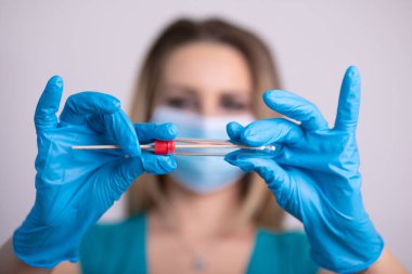 Coronavirus COVID 19 test kiti, PPE koruyucu maskesi ve eldiven taşıyan yüz maskeli hemşire, OP NP hasta numunesi almak için tüp, PCR DNA RNA test protokolü fotoğrafı