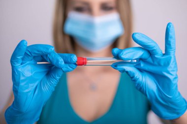 Coronavirus COVID 19 test kiti, PPE koruyucu maskesi ve eldiven taşıyan yüz maskeli hemşire, OP NP hasta numunesi almak için tüp, PCR DNA RNA test protokolü fotoğrafı