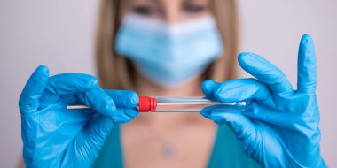 Coronavirus COVID 19 test kiti, PPE koruyucu maskesi ve eldiven taşıyan yüz maskeli hemşire, OP NP hasta numunesi almak için tüp, PCR DNA RNA test protokolü fotoğrafı