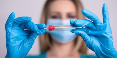 Coronavirus COVID 19 test kiti, PPE koruyucu maskesi ve eldiven taşıyan yüz maskeli hemşire, OP NP hasta numunesi almak için tüp, PCR DNA RNA test protokolü fotoğrafı