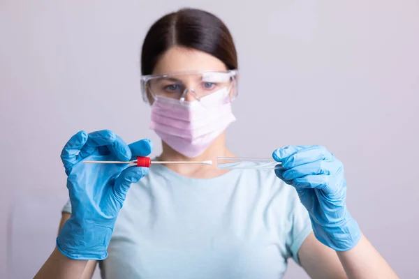 Medical healthcare doctor nurse holding Coronavirus COVID-19 swab test kit, PPE protective mask and gloves, tube for taking OP NP patient specimen sample, PCR DNA RNA protocol process stock photo