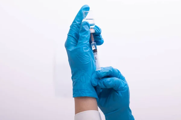 Doctor Scientist in protective gloves holding glass vial with injection liquid. Vaccination against influenza and coronavirus. Stock photo
