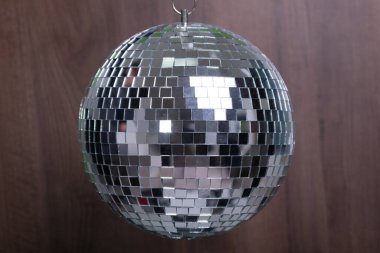 Shining Disco Ball dance music event equipment on wood background