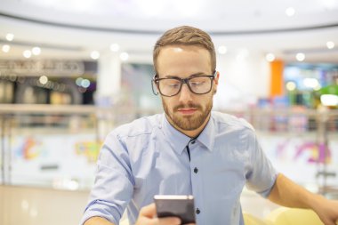 Genç işadamı oturma restoranda ve kullanım mobil de tablo