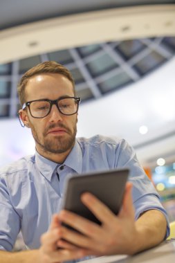 Genç işadamı oturma restoranda ve kullanım mobil de tablo