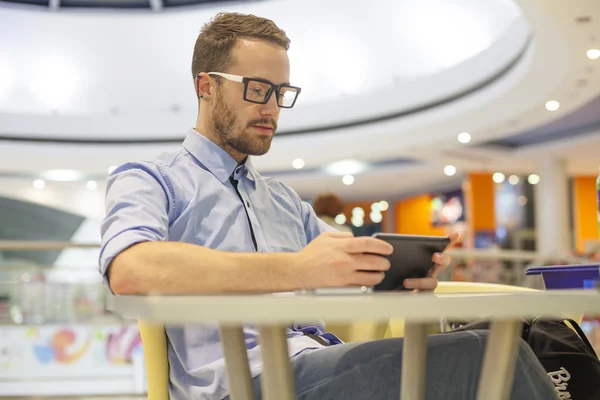 Genç işadamı oturma restoranda ve kullanım mobil de tablo